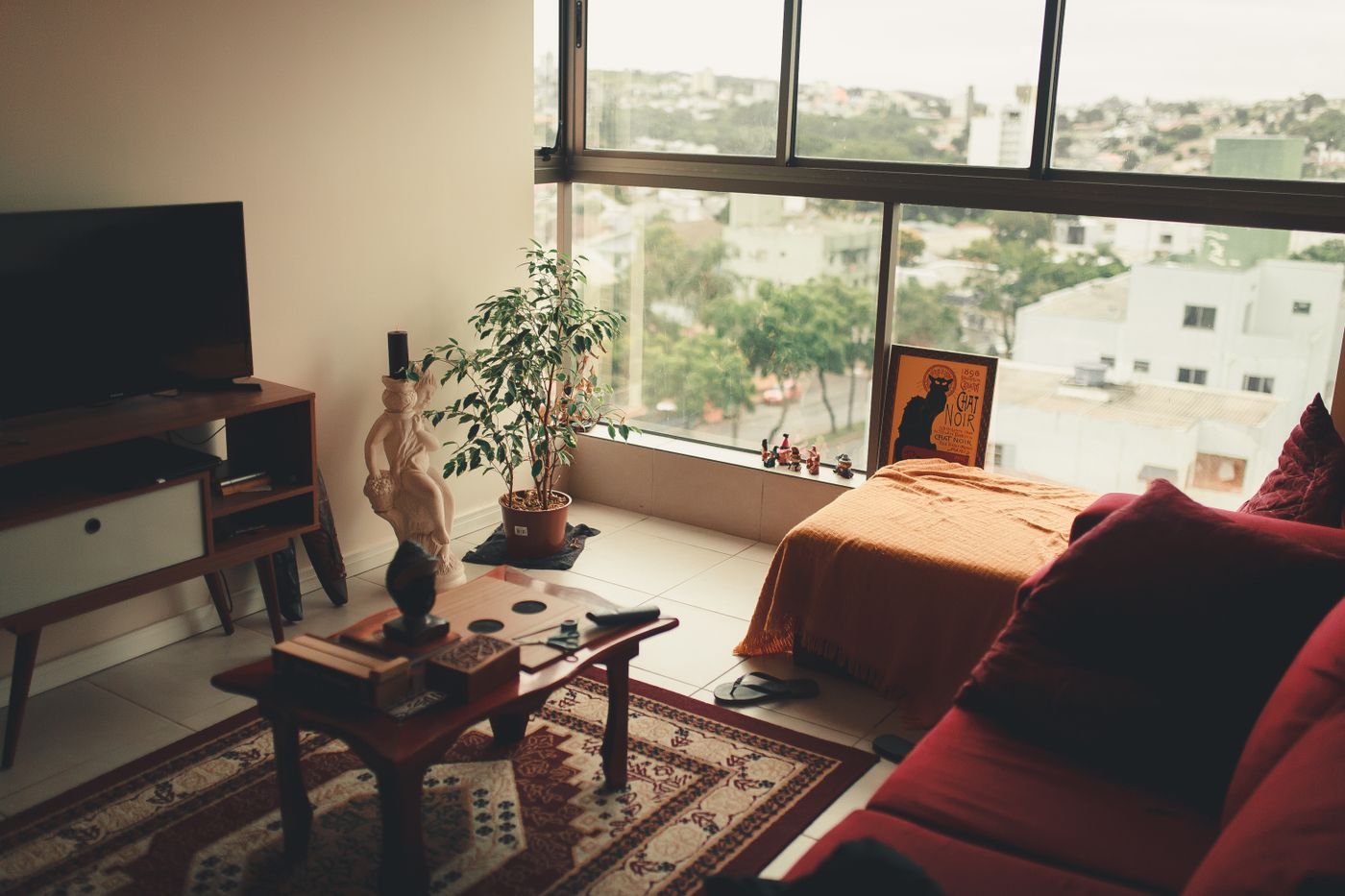 Window-side living area with a sofa, coffee table and warm textiles